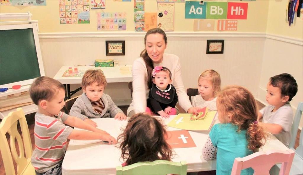 Toddlers gathered for circle time with teacher at Kiddie Care Early Learning Damascus MD