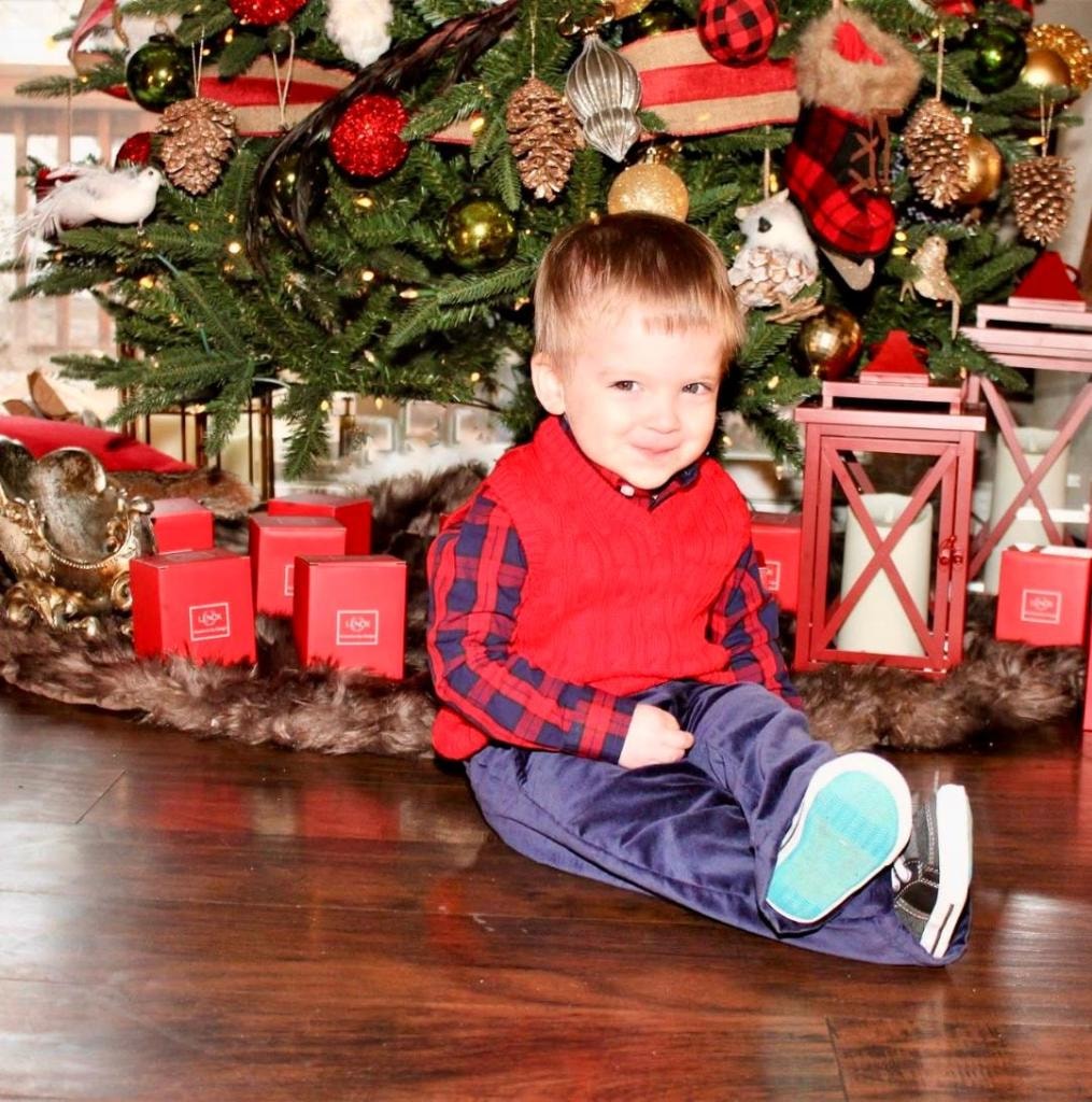 Little boy posing by the Christmas tree at Kiddie Care preschool