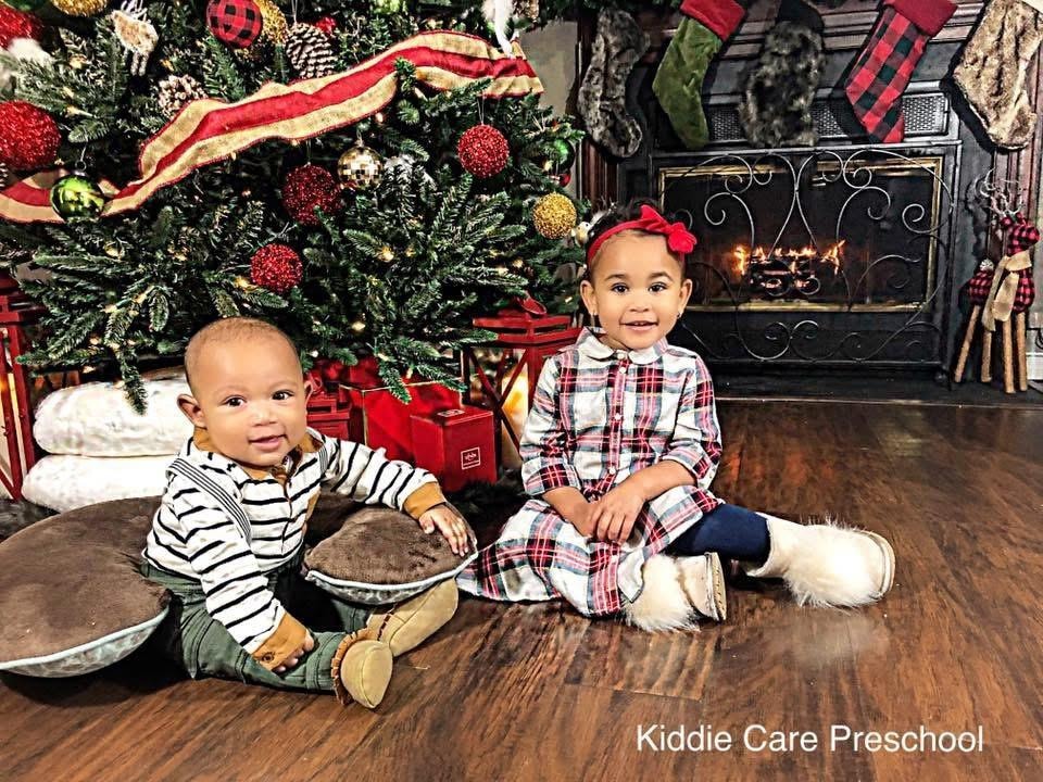 Two children by the fireplace celebrating Christmas at Kiddie Care Early Learning