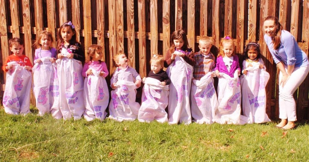 Whole group in bunny hop sacks at Kiddie Care Easter celebration