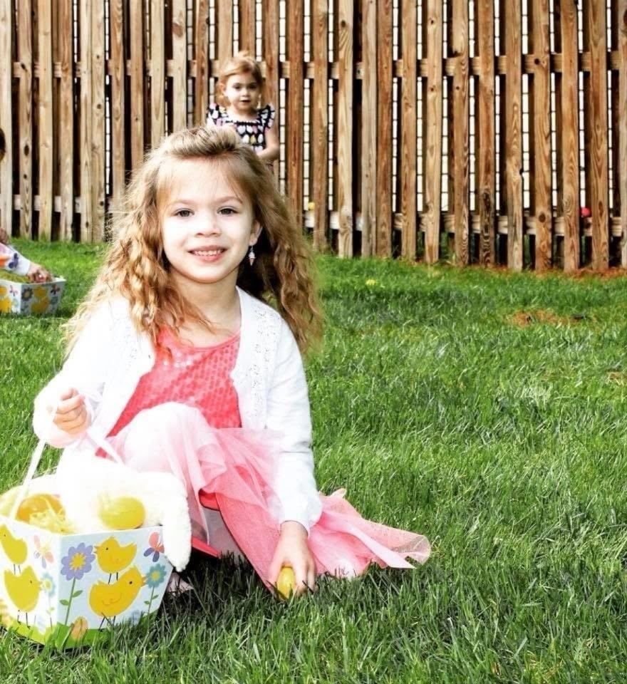 Girl in pink dress at Kiddie Care Easter egg hunt