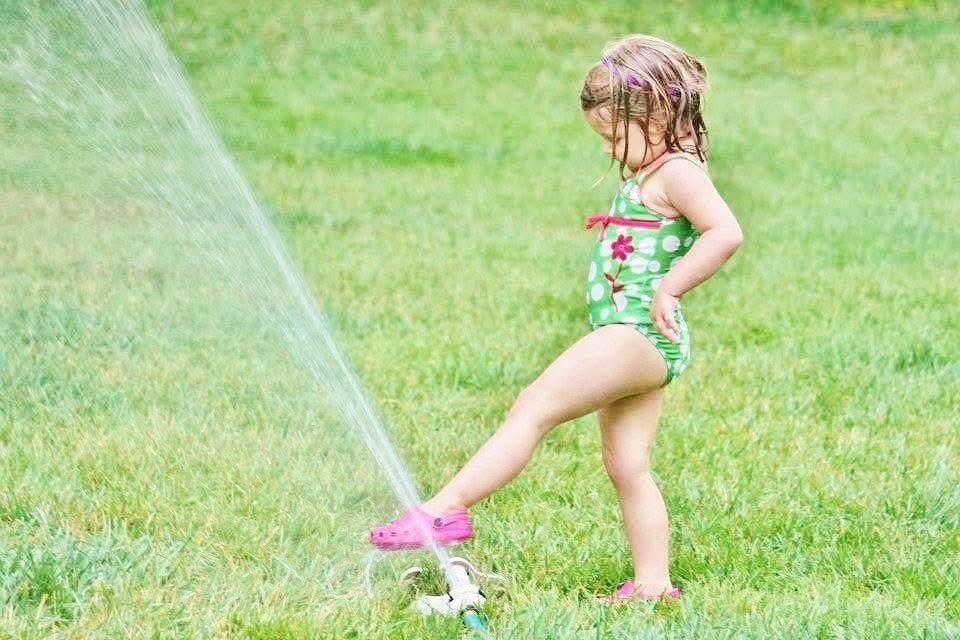Summer sprinkler fun at Kiddie Care home daycare